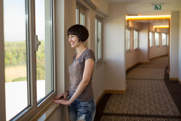 Молодая девушка любуется красивым видом из окна отеля