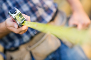 Carpenter Holding Tape Measure Outdoors