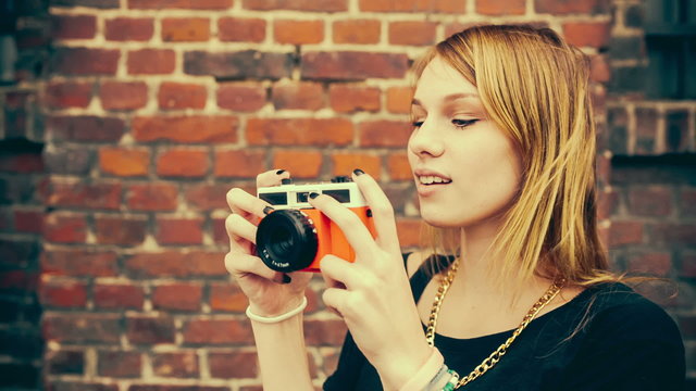 Hipster girl taking photos with vintage camera