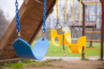 Bright yellow and blue chain swings on kids playground