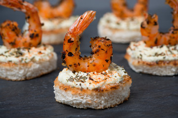 festive appetizer with spicy shrimps on toast, close-up