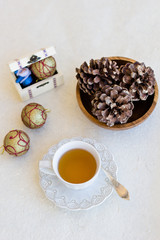 Christmas composition with cup of tea, balls and bumps