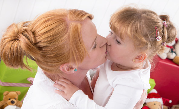 Mutter und Tochter geben sich einen Kuss