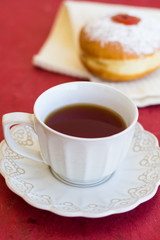 A cup of tea with fresh donut