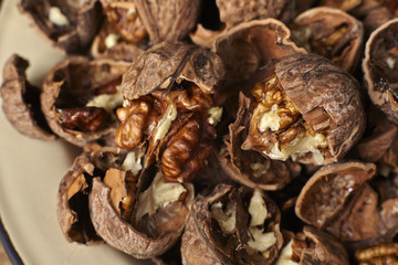 Close up of walnuts cracked open on a wooden table