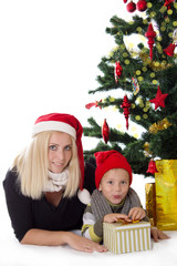 Obraz na płótnie Canvas Mother and son lying under Christmas tree