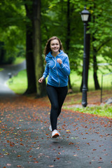 Young woman running in city park