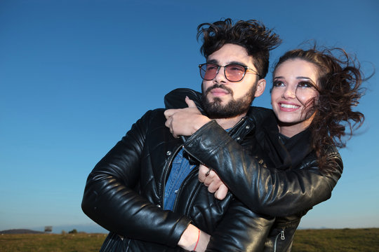 smiling woman embracing her lover and both looking away