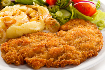 Fried pork chops, boiled potatoes and vegetable salad