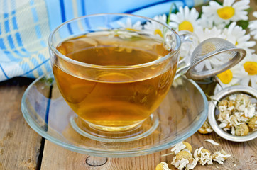 Herbal chamomile tea dry in a strainer with a glass cup