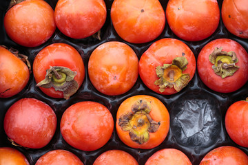 persimmons in a fruit container - kaki