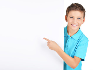 Portrait of  cheerful boy pointing on white banner