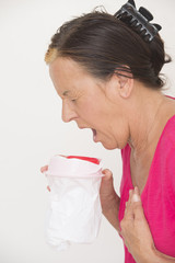 Sick woman vomiting in bag