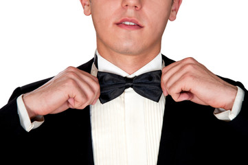 man in a black suit adjusts his bow tie close-up face