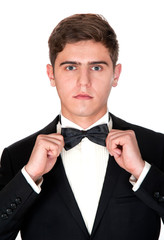 man in a black suit adjusts his bow tie