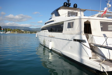 Grand yacht à moteur super blanc amarré au port avec une mer calme