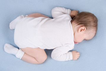 Baby sleeps on soft blue blanket. Top view