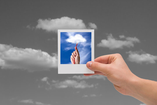 Holding Instant photo. Cloud computing concepts.