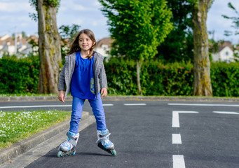 Pretty little girl doing rollerblade in the street
