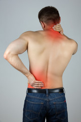 Young man touching his back and neck for the pain