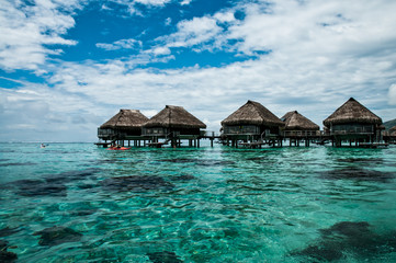 Overwater bungalows inside a lagoon of Moorea in polynesia