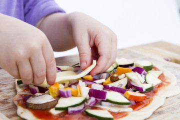 small hands preparing pizza