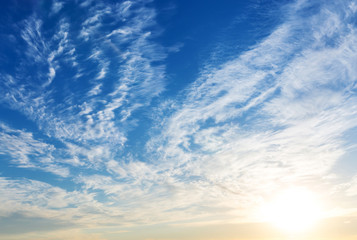 Blue sky with sun and clouds.