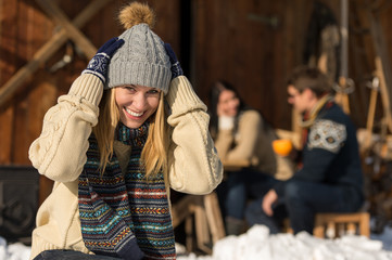 Young woman in winter hat snow cottage