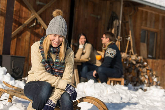 Young woman with friends snow winter cottage