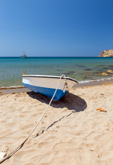 Summer seascape in a Greek island with a small boat on the beach