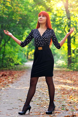 Beautiful girl standing in a park in autumn.