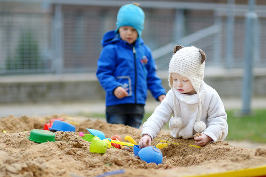 Two kids playing in a sandbox