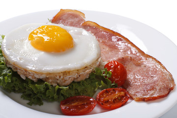 Fried egg on rice cakes with vegetables and ham on a white