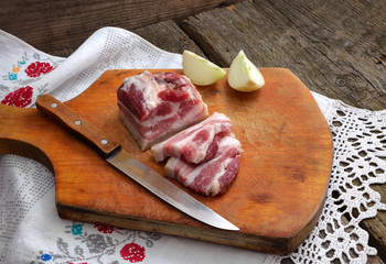 Bacon and onion on an old board.