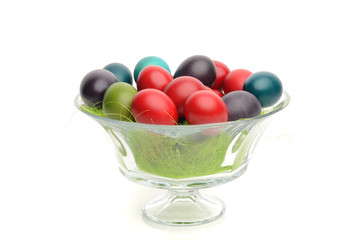 Hand dyed easter eggs in a glass bowl decorated with grass