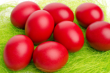 Close up on red hand dyed easter egg on fake grass.