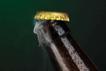 Top of open wet beer bottle on dark background