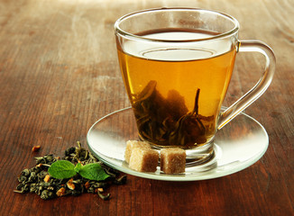 Transparent cup of green tea on wooden background