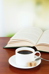 Cup of coffee with sugar and book