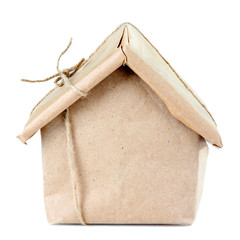 House wrapped in brown kraft paper, isolated on white