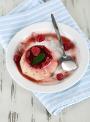 Panna Cotta with raspberry sauce, on wooden background
