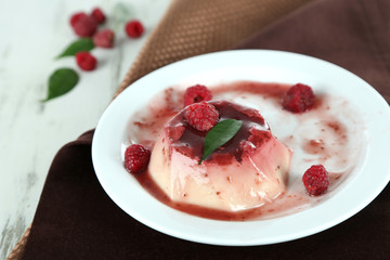 Panna Cotta with raspberry sauce, on wooden background