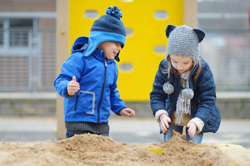 Two kids playing in a sandbox