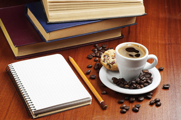 Cup of coffee, notepad and books