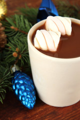 Cup of hot cacao with Christmas decorations on wooden