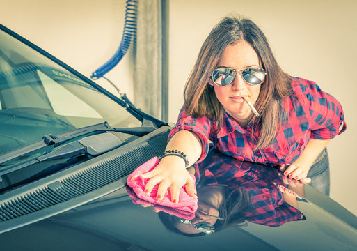 Young beautiful woman cleaning her Car at Carwash