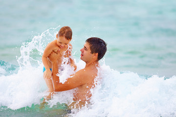 playful father and son having fun in water