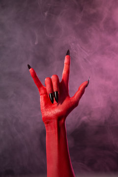 Heavy metal, red devil hand with black nails