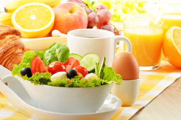 Breakfast with coffee, orange juice, croissant, egg, vegetables
