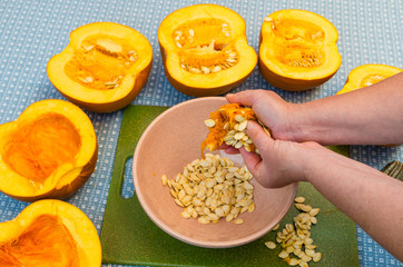 A cook extracting the seeds from a pumpkin